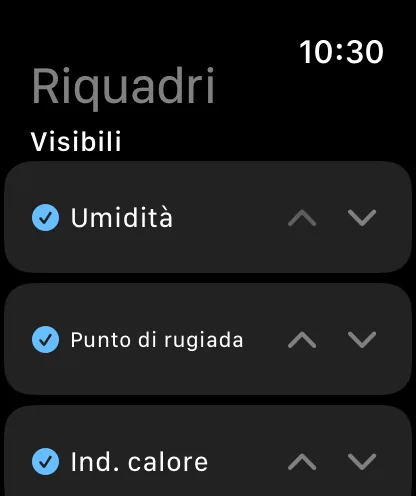 La schermata Riquadri sull’orologio, intitolata Riquadri e Mostrati, con Umidità, Punto di rugiada e Indice di calore selezionati e dotati di frecce su e giù.