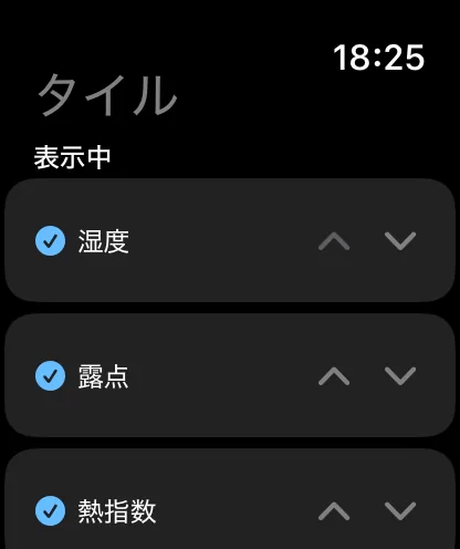 Apple Watchのタイル画面。“タイル”と“表示中”という見出しの下で、湿度、露点、熱指数にそれぞれチェックが付き、上下の山形のボタンがあります。
