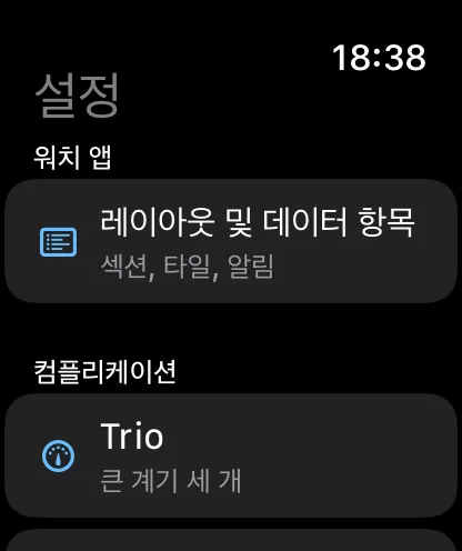 워치 앱의 설정 화면. ‘섹션, 타일, 알림’이라는 부제가 있는 레이아웃 및 데이터 항목이 포함된 워치 앱 섹션이 있고, 그 아래에 ‘Trio, 세 개의 큰 게이지’로 시작하는 컴플리케이션 섹션이 있습니다.