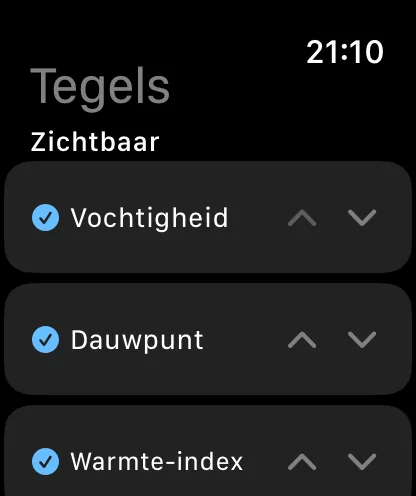Het scherm Tegels op de Watch, met de koppen Tegels en Zichtbaar, met Vochtigheid, Dauwpunt en Warmte-index elk aangevinkt en met pijltjes omhoog en omlaag.
